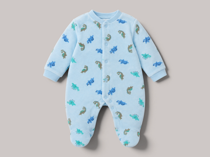 Pijama de bebé NAVIA en color azul claro con estampado de dinosaurios, confeccionado en algodón suave y transpirable.