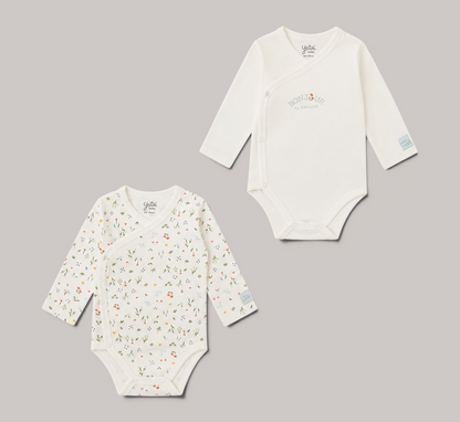 Pack de 2 bodies cruzados NAVIA YATSI BABY, uno blanco con estampado floral y otro con texto, manga larga, algodón.