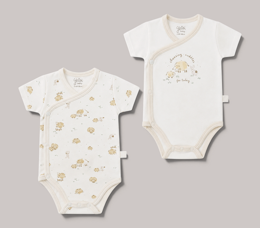 Pack de 2 bodies NAVIA YATSI BABY de manga corta en color crema con estampado de ovejitas para bebés de 0 a 6 meses.