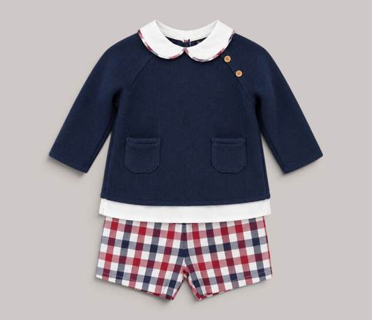 Conjunto NAVIA de bebé con jersey azul marino de punto, cuello bebé y pantalón corto de cuadros rojos y blancos.