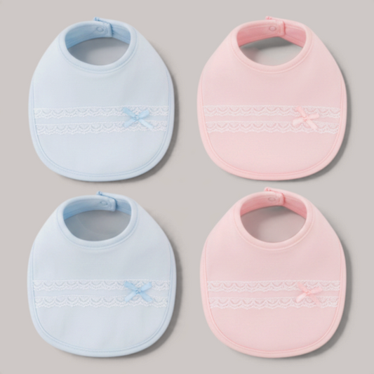 Set de baberos NAVIA de algodón en azul y rosa con detalles de encaje y lazo, ideales para la piel del bebé.