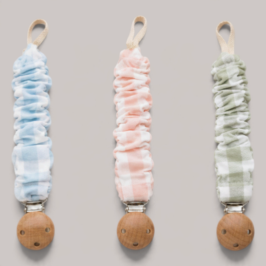 Tres chupeteros NAVIA de algodón con estampado vichy en azul, rosa y verde, con clip de madera natural para bebé.