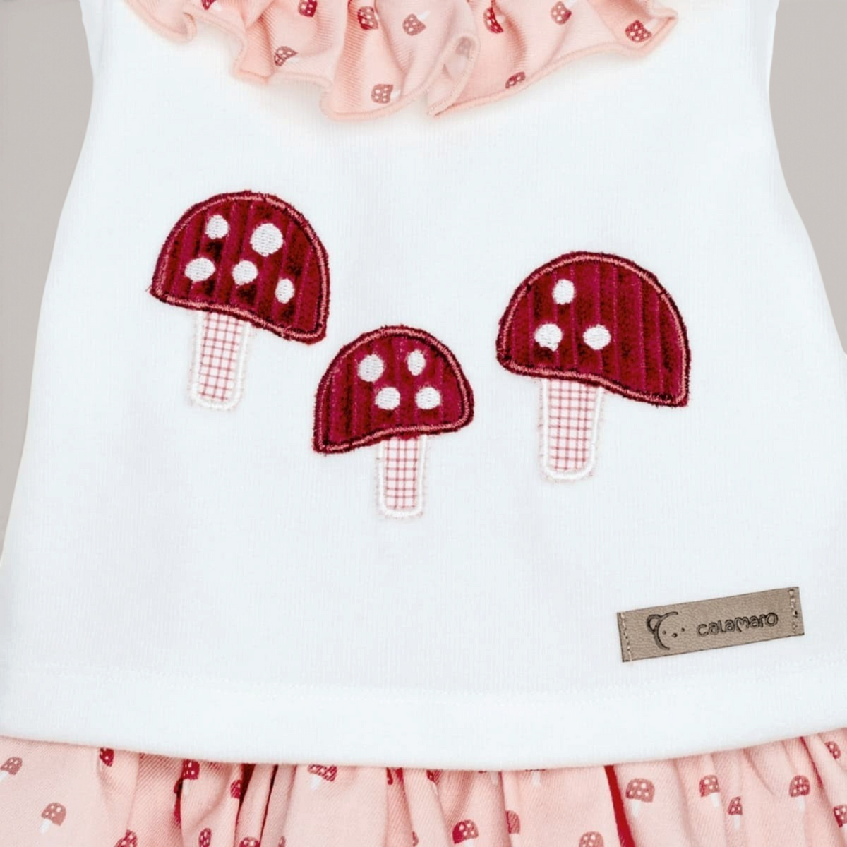 Conjunto NAVIA Calamaro con jersey blanco de cuello volante y pololo rosa estampado con setas bordadas para bebé