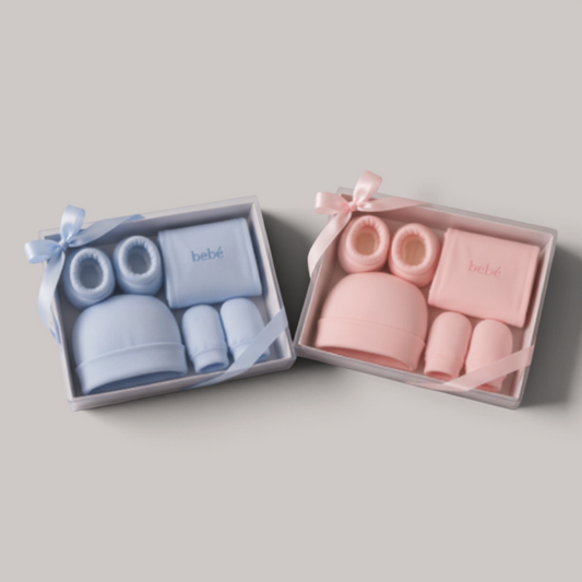 Canastilla de regalo NAVIA para bebé con gorro, patucos y manoplas de algodón suave en tonos celeste y rosa pastel.
