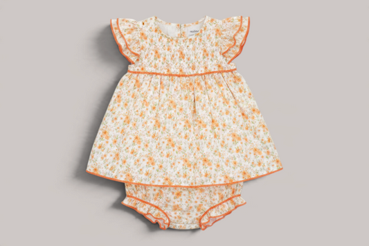 Conjunto NAVIA de bebé con estampado floral melocotón, algodón suave, detalles fruncidos y volantes en las mangas.